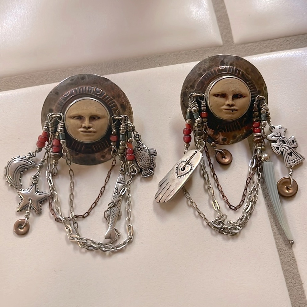Reminds me of Aztec mythology with the sun, moon, stars, fish. Lots of dangles.